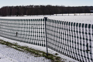 ein Schneeauffangzaun im Winter