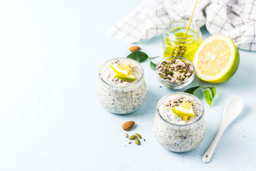 Lemon poppy seed overnight oats with honey on light blue background. Selective focus, space for text.