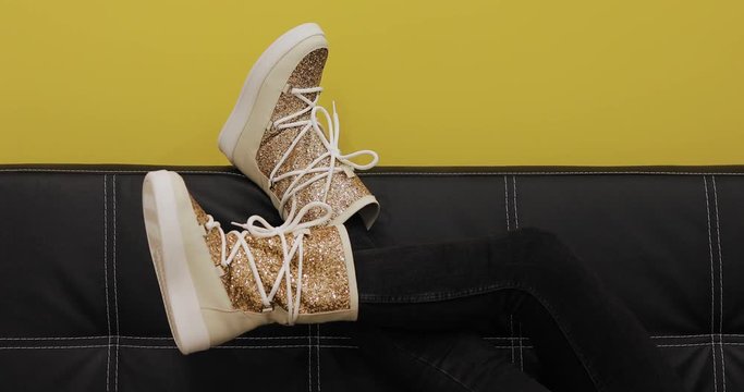 Ugg boots on women legs at color wall background, creative video