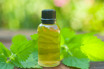 nettle essential oil in  beautiful bottle on table