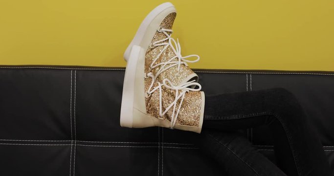 Ugg boots on women legs at color wall background, creative video