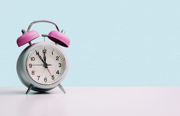 Retro styled white alarm clock, isolated and copy space, pink blue