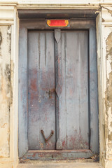 Old ancient weathered double doors in Thai temple.