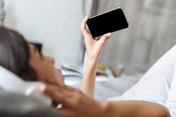 Beautiful young woman relaxing on a couch at home