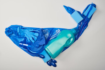 top view of whale figure made of rubber gloves, plastic plates, cups, sponges, spoons, bag and...