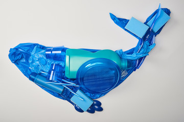 top view of whale made from disposable plastic tableware, bag, bottle, sponges and rubber gloves...