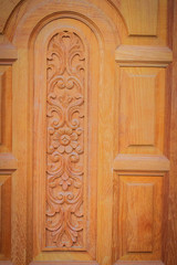 Artwork on door leave with arched shape, carving flower textured and rectangular patterns.