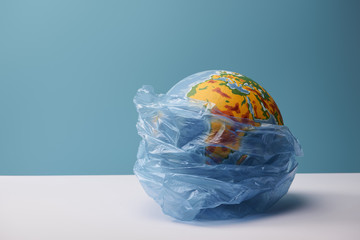 globe in polyethylene bag on white table and blue background