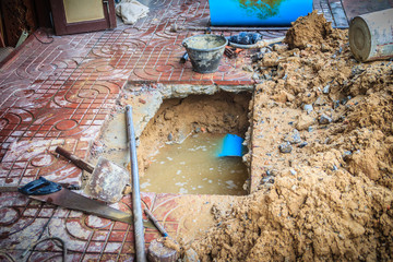 Underground PVC pipe of the water supply is broken and being repaired by the plumber.