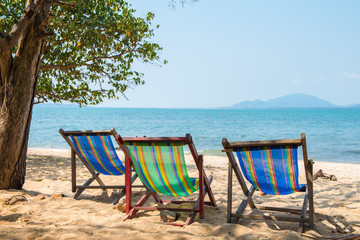 Beach chairs on the white sand beach and tropical sea.