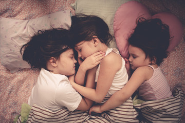 Funny children siblings are sleeping in an embrace