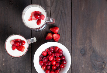 Milk shake with strawberries or breakfast with muesli and yogurt and berries on a dark background