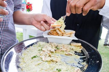 Waiter serving tasty salmon carpaccio at an event.