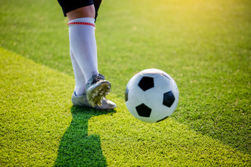 Soccer player speed run to shoot ball to goal on artificial turf