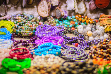 Colorful bracelets, beads and necklaces souvenir for sale on street at Khao San Road night market, Bangkok, Thailand.