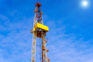 Oil and Gas Drilling Rig onshore dessert with dramatic cloudscape. Oil drilling rig operation on the oil platform in oil and gas industry. Land drilling rig blue sky