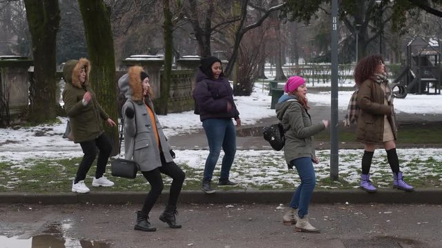 slow motion five young women multiethnic outdoor snow field having fun dancing - happiness, friendship, positive emotions concept