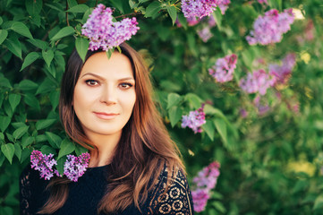 Spring portrait of beautiful brunette woman wearing black lace dress