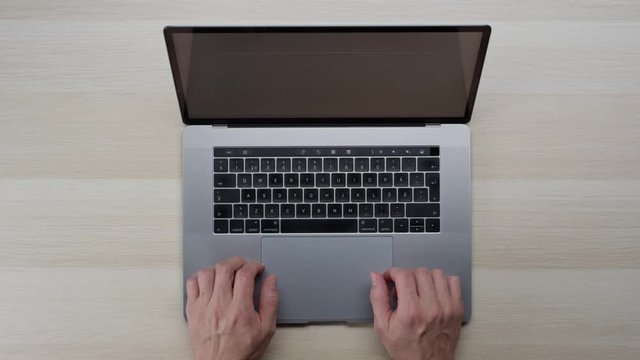 Male hands typing laptop on white clean minimalistic table with top view, gestures and finger movements