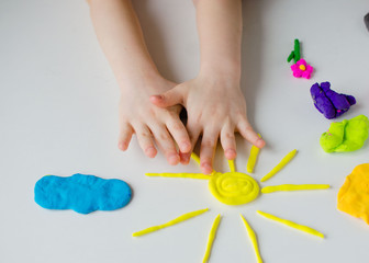 Obraz na płótnie Canvas Child hands playing with colorful clay. Homemade plastiline