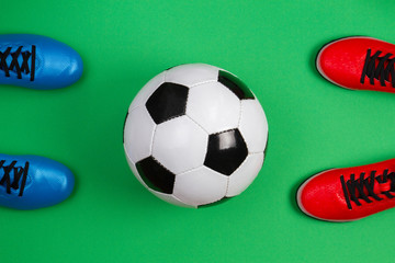 top view to soccer ball between soccer players feets on green background