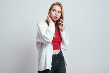 Important talk. Close-up portrait of young woman in casual wear talking about something important with friends by her smartphone. Communication concept