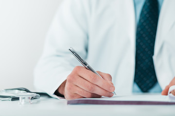 Close up of Young Doctor on the Job writing down diagnosis