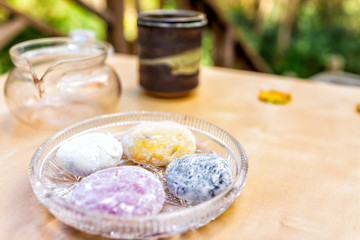 Tea pot and mochi rice cake Japanese dessert wagashi colorful daifuku on table color with four pieces closeup
