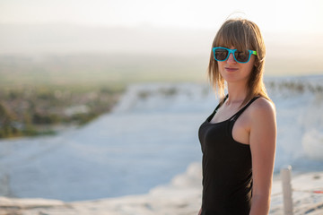 Natural travertine pools and terraces in Pamukkale. Cotton castle in southwestern Turkey, girl standing in natural pool. A woman in the pool of thermal springs and travertine Pamukkale