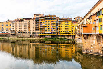 Fototapeta na wymiar Florence, Italy Firenze orange yellow colorful building on Ponte Vecchio by Arno river during summer morning in Tuscany with nobody vibrant