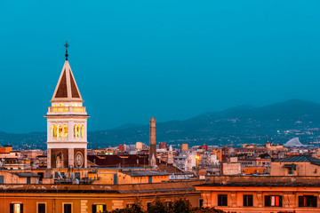 Fototapeta premium Historic Italian town of San Lorenzo in Rome, Italy cityscape skyline with view of colorful red architecture old buildings church tower at dark blue night