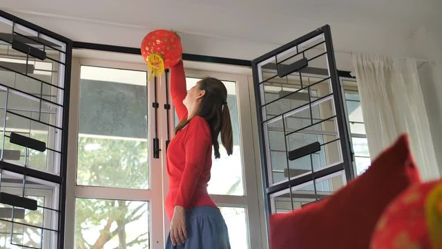 Slow motion, Happy Asian woman decorate her house for Chinese New Year Celebrations