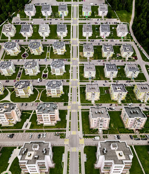Modern townhouses in a residential area with multiple new apartments buildings surrounded by green outdoor facilities aerial view with dronception special effect