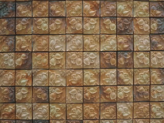 Flower patterned clay tiles decorated on leather and have a beautiful texture as the background.