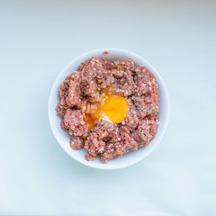 Raw minced meat with egg and  spices for cooking cutlets, burgers, meatballs. Concept- cooking, recipes, delicious dishes.
