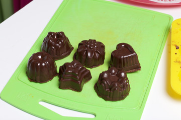 Cooking sweets with coconut and condensed milk. In a glaze of white and black chocolate.