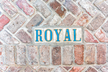 Historic old town Royal street sign on sidewalk pavement in New Orleans, Louisiana famous town city during day flat top view down