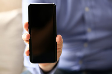 Businessman arm expose monitor of cellphone to camera closeup