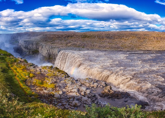 Amazing nature landscape, stunning Dettifoss waterfall with rocky canyon and blue cloudy sky Iceland. Scenic panoramic aerial view, outdoor travel background. Vatnajökull National park