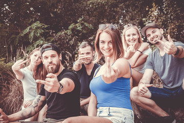 naughty millennials without gadget show you their middle fingers with a big smile