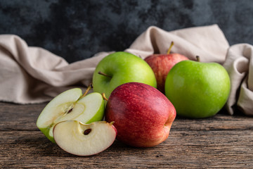Red and green apples on wooden background.