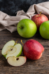 Red and green apples on wooden background.