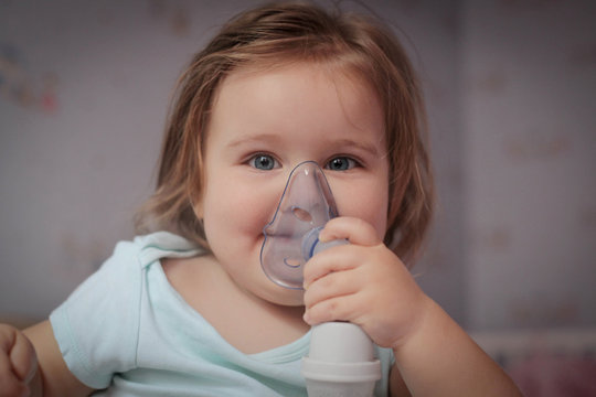 Asthma, little girl with inhaling mask.