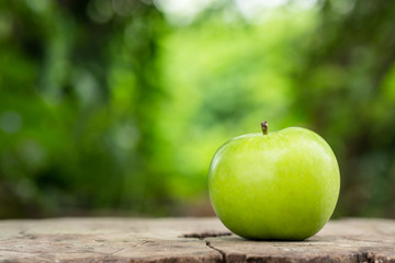 One green apple on wooden background.