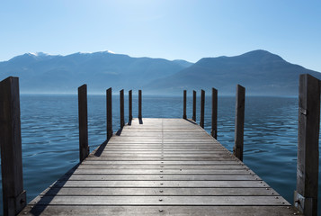 Pier on an Alpine Lake with Mountain and Blue Sky in Switzerland.
