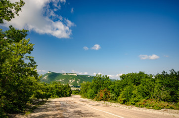 Fototapeta na wymiar Ukrainian Crimean rural road under blue sky summer sunny day