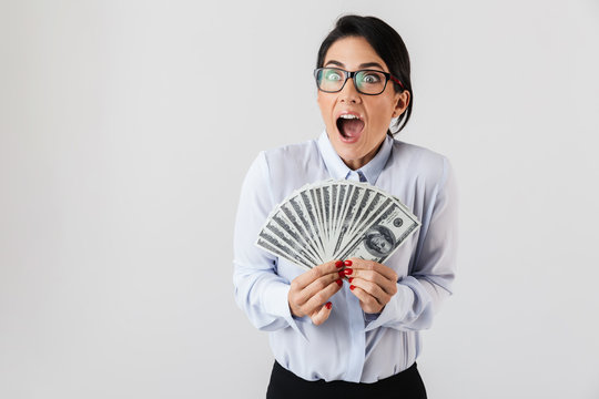 Image of rich secretary woman wearing eyeglasses holding bunch of money in the office, isolated over white background