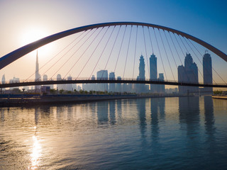 Naklejka na ściany i meble Panorama of the city early in the morning at dawn with a bridge over the city channel Dubai Greek.