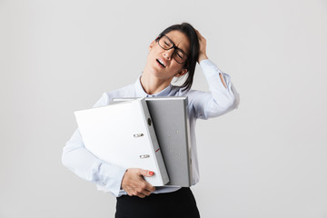 Photo of businesswoman wearing eyeglasses holding paper folders in the office, isolated over white background