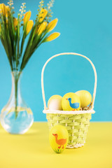 Easter basket with eggs on yellow background.